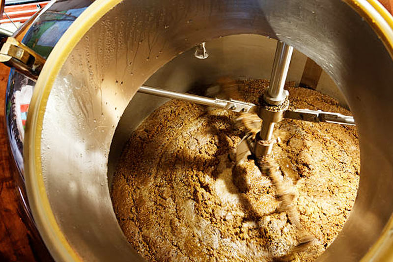 What is the purpose of a mash tun in the brewing process？